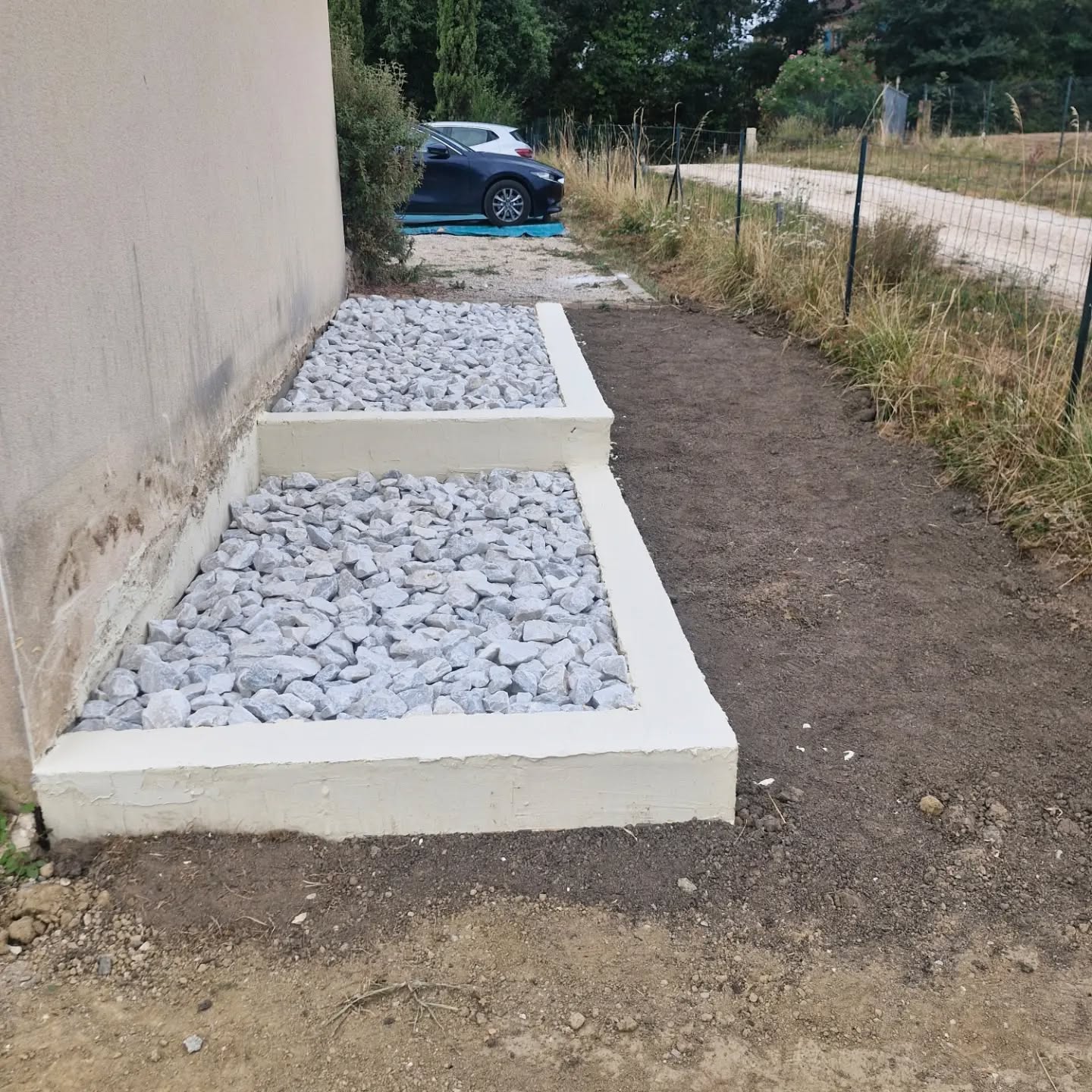 Aménagement extérieur minéral propre le long d’une maison réalisé par lj, paysagiste à Gimont