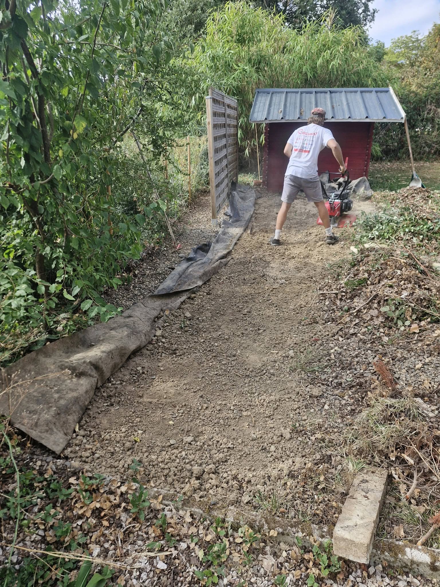 Ouvrier lj préparant un jardin avec motobineuse dans un cadre verdoyant à gimont