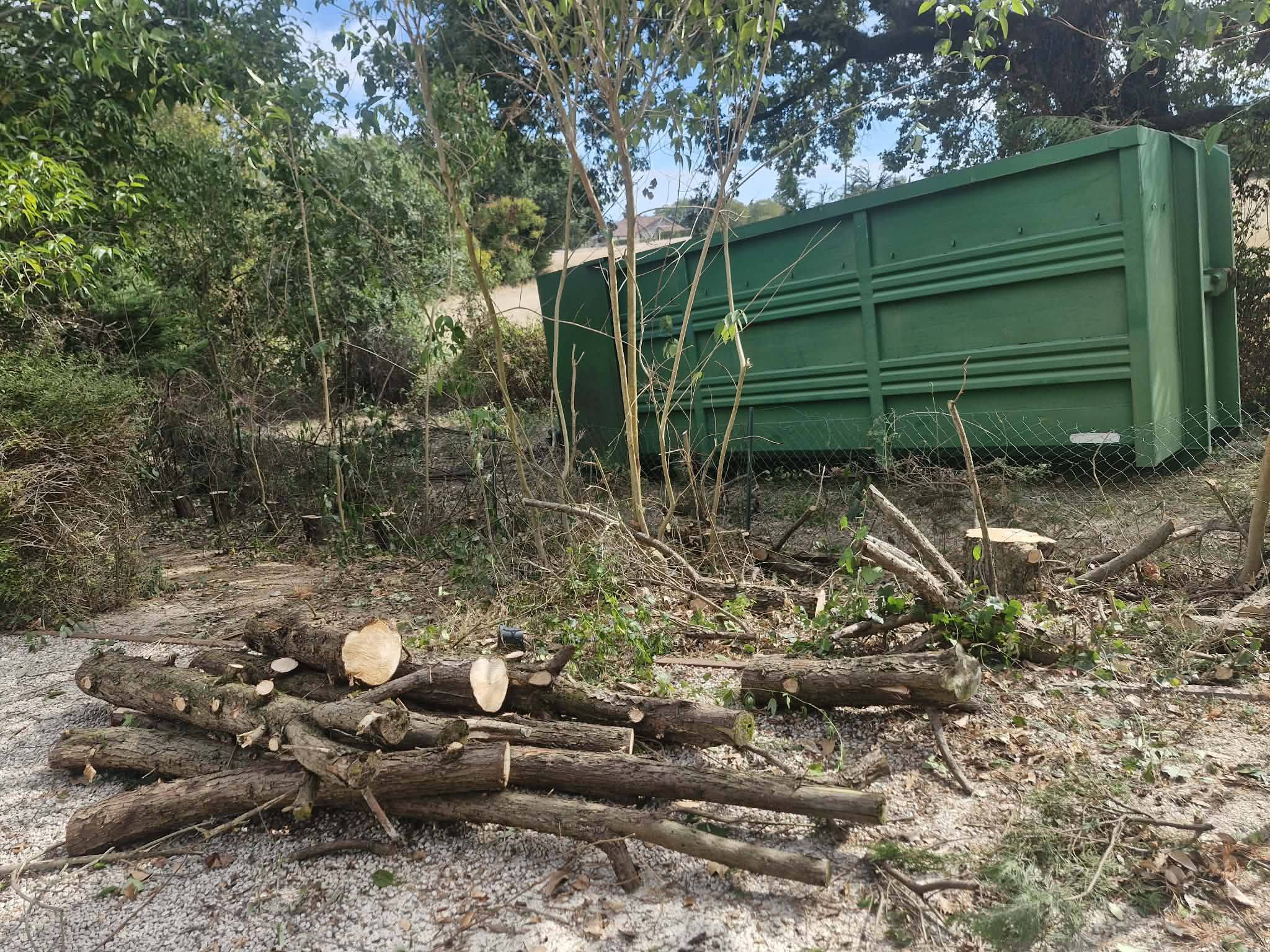 Tas de bûches et benne à déchets verts sur chantier d’élagage lj près de gimont